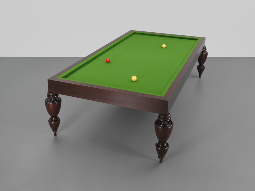 Elegant billiards table with green felt and three balls, on a gray background.