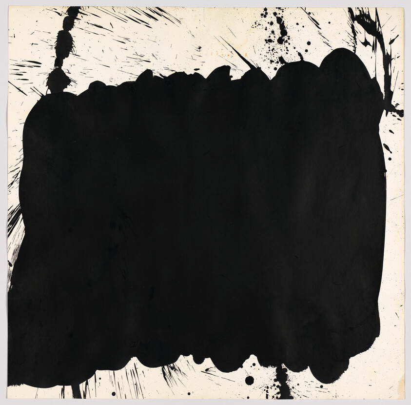 A large irregular black ink blot covers most of the cream-colored paper with splatters.