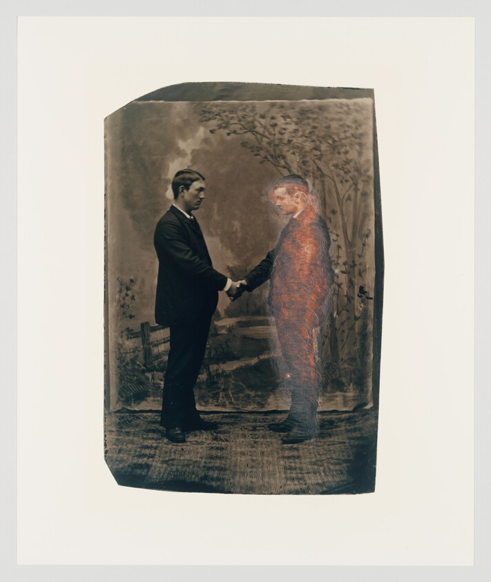 Two men shake hands, one appearing as a translucent, glowing figure.