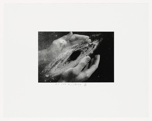 Two hands cupping a swirling galaxy or black hole made of dust and stars.