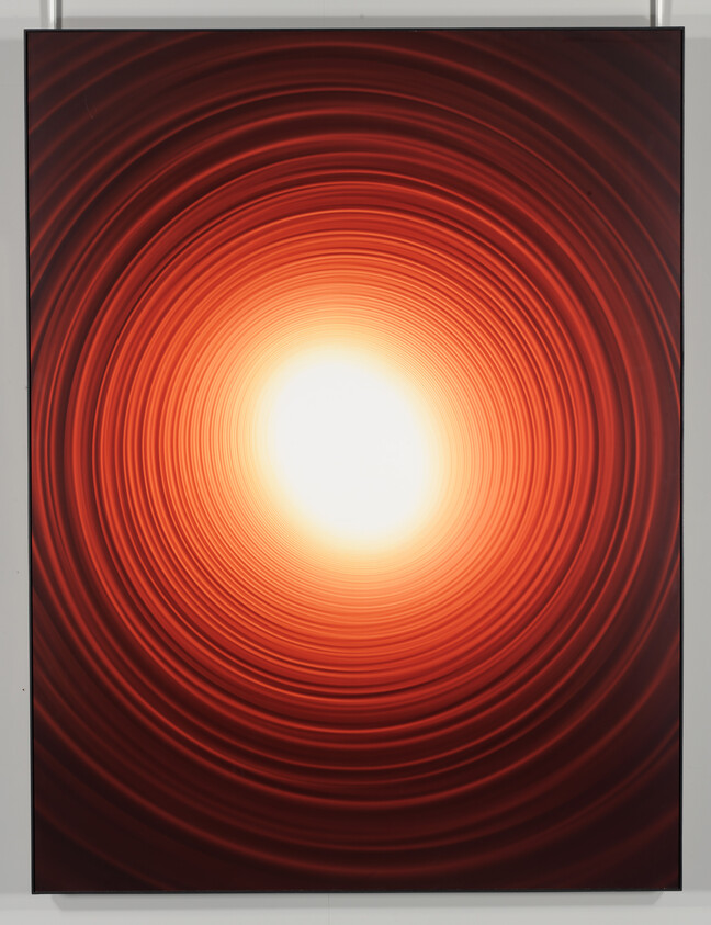 Concentric red-orange rings radiate toward a bright glowing center like a tunnel of light.