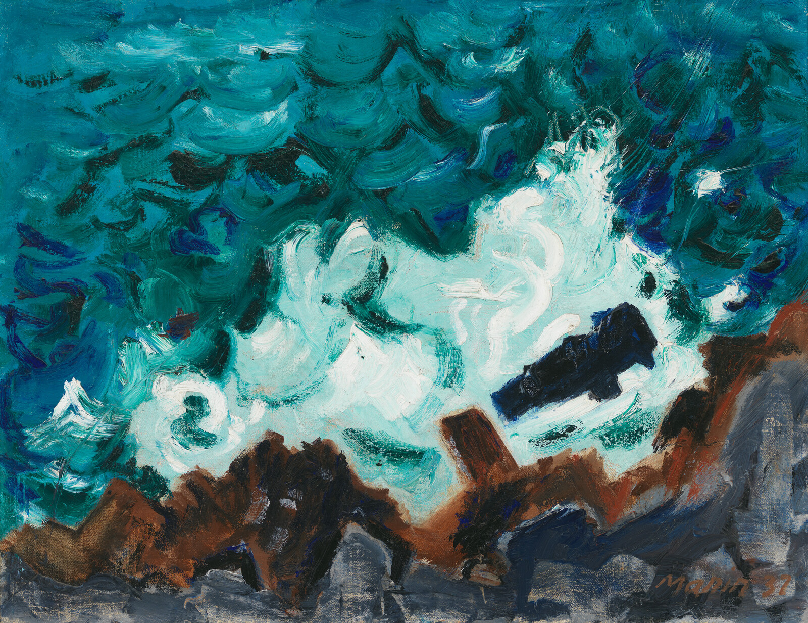 Turbulent turquoise waves crashing against jagged brown rocks with a dark object caught in the surf.