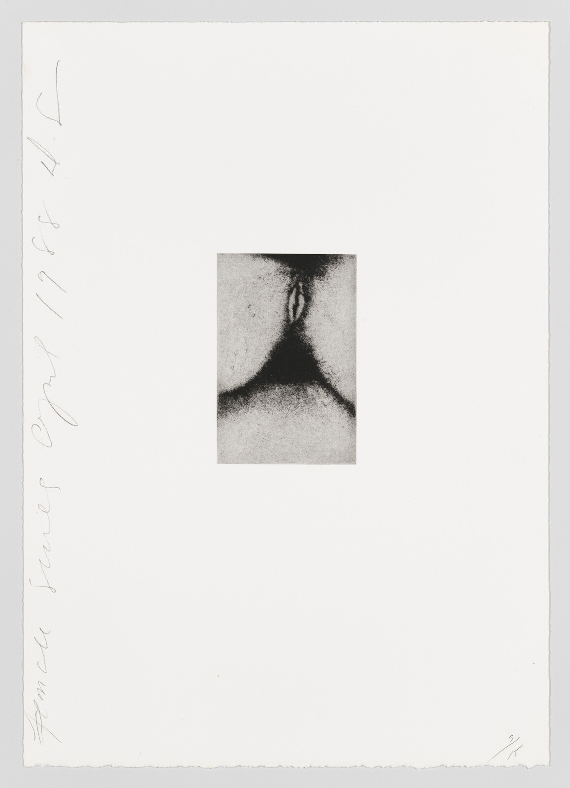 Small monochrome print centered on a large white sheet showing a close-up of a vulva-like form.