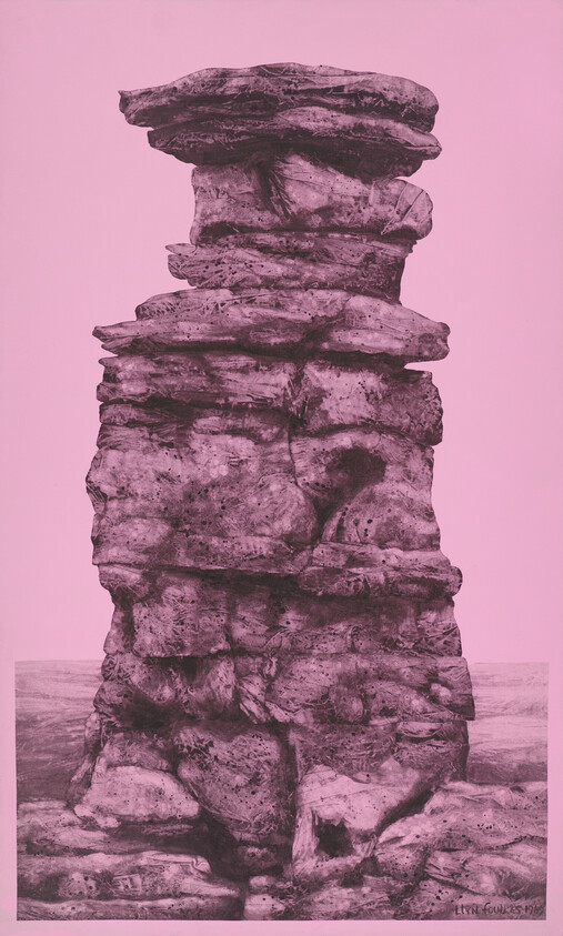Tall layered sea stack rock formation standing on a flat shoreline with pink tone.