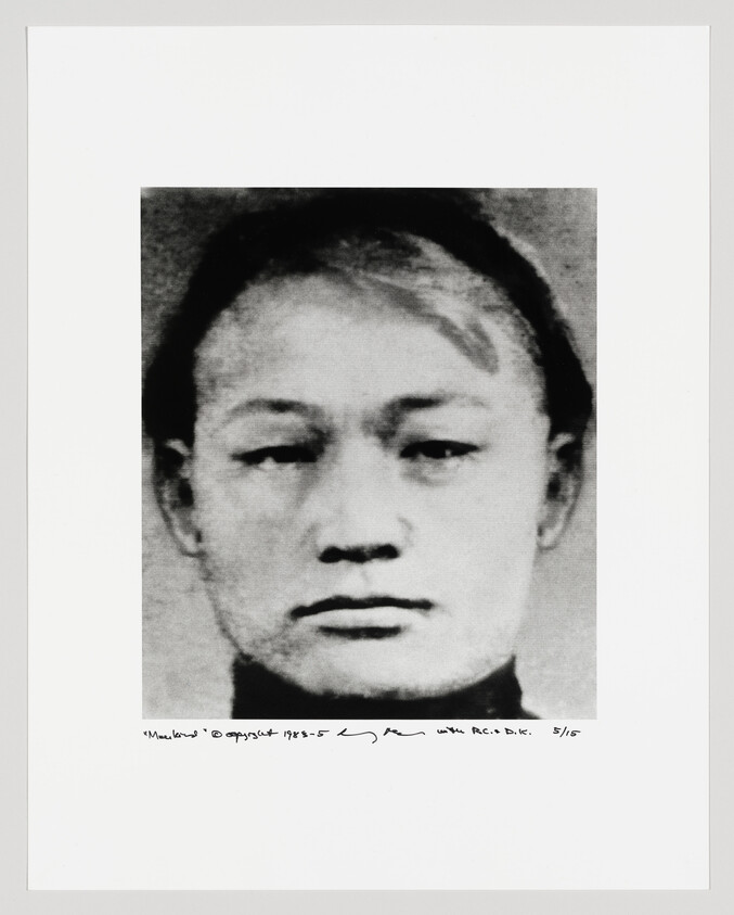 Black and white portrait of a person with a neutral expression, cropped to show only the face and part of the neck. The image is grainy and appears to be an enlargement of a smaller photograph. Below the image, there is handwritten text and a signature, indicating that this is a numbered piece of artwork.