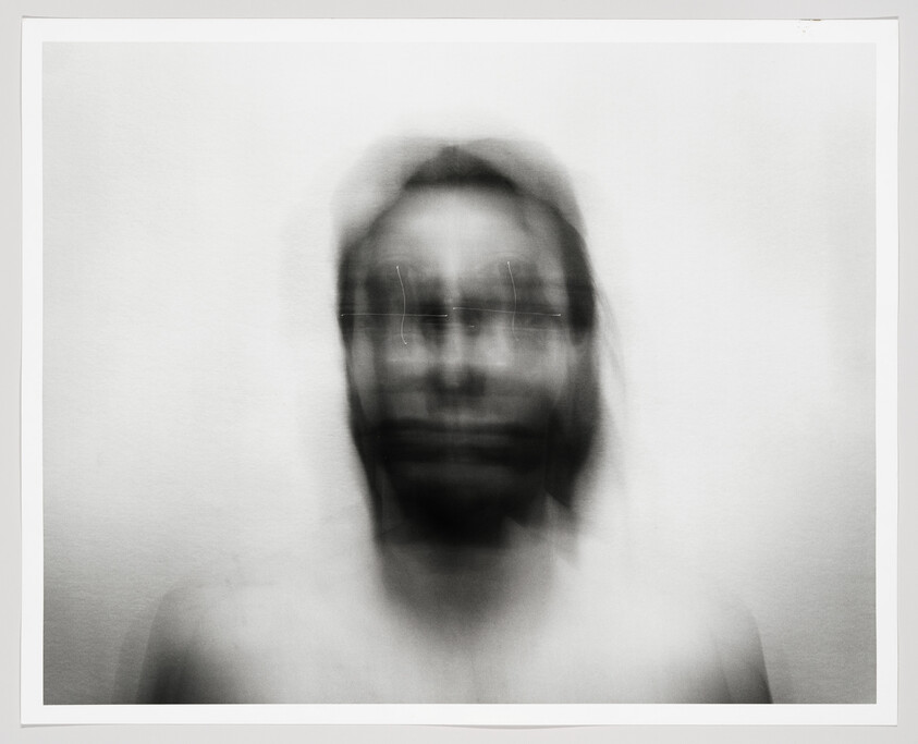 Blurred portrait of a person with double exposure effect and faint glasses.