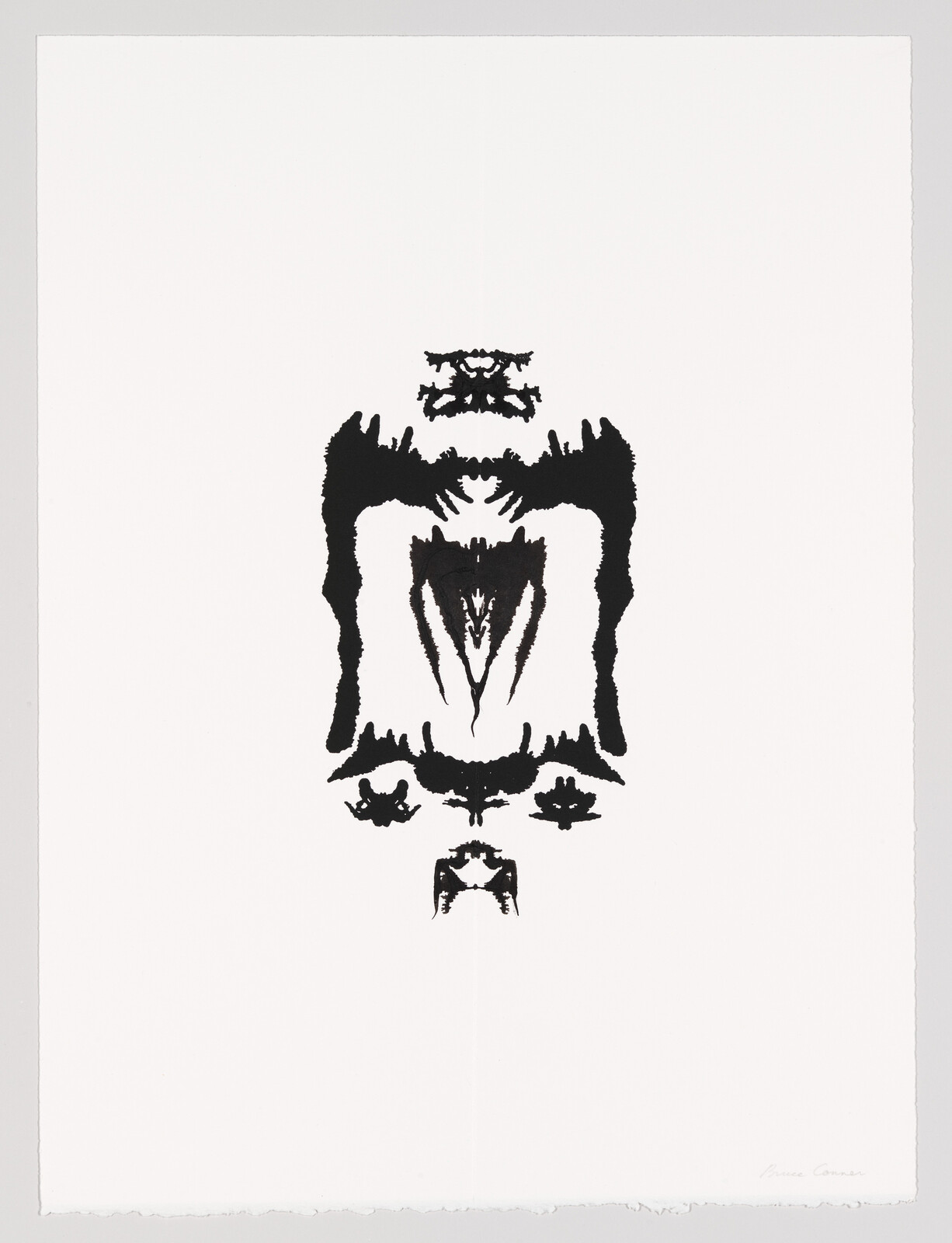 A symmetrical black inkblot resembling abstract creatures is centered on a white sheet of paper.