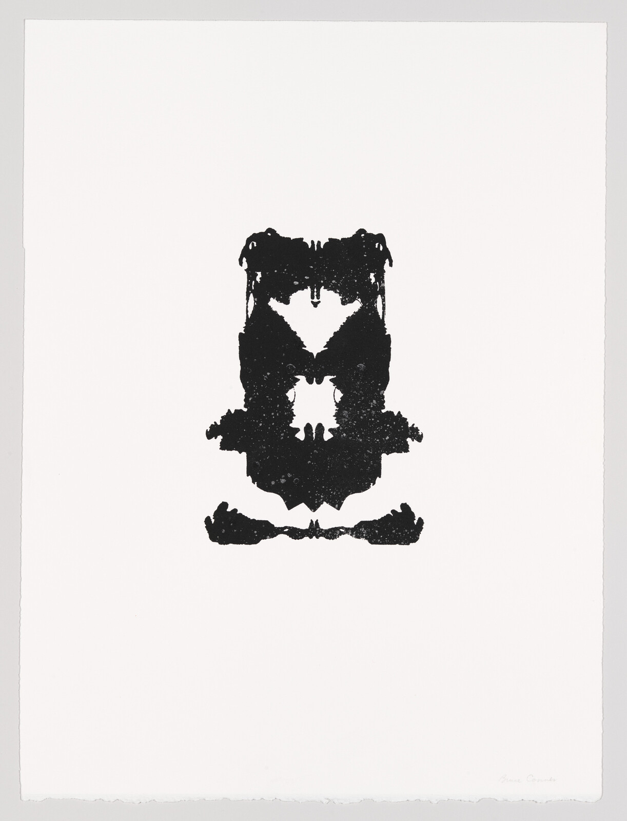 Centered black symmetrical inkblot resembling a seated owl or masked face on white paper.