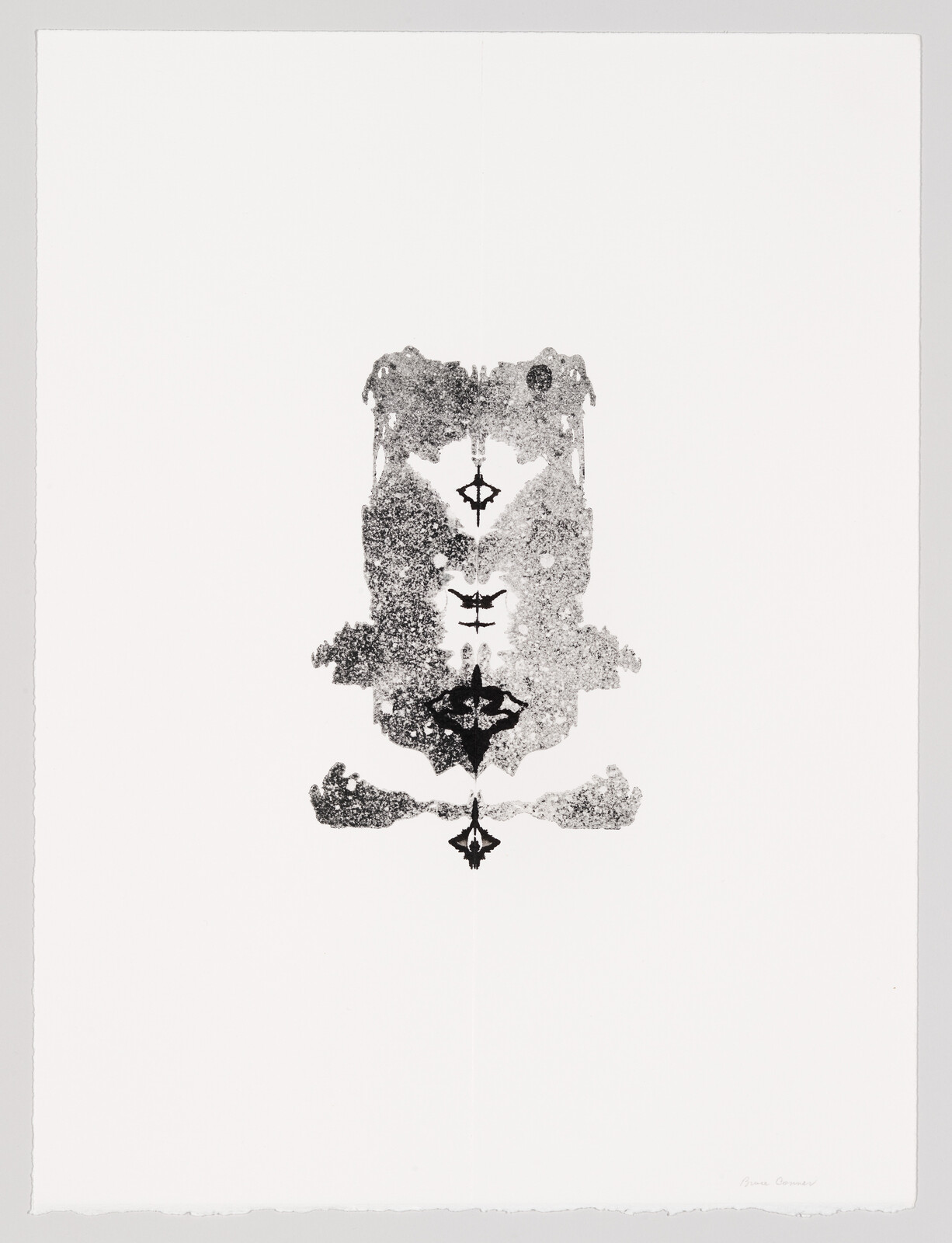Symmetrical black ink blot centered on white paper resembling a Rorschach test.