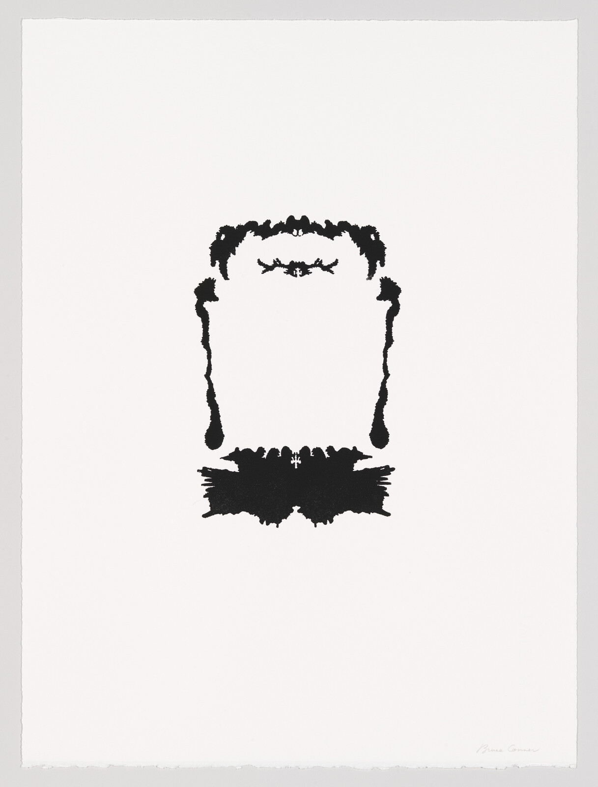 A symmetrical black inkblot centered on white paper resembling an abstract face or frame.