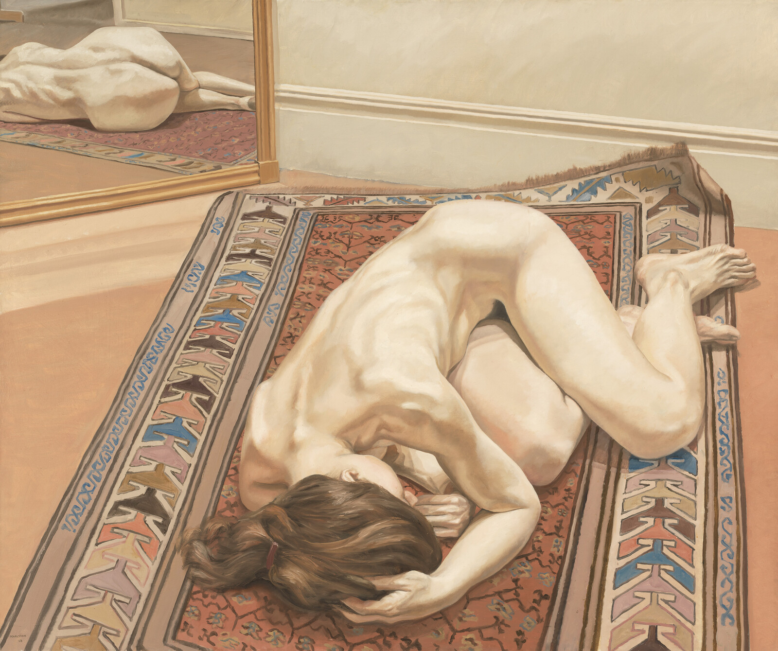 A naked woman curled on a patterned rug next to a mirror reflecting her back.