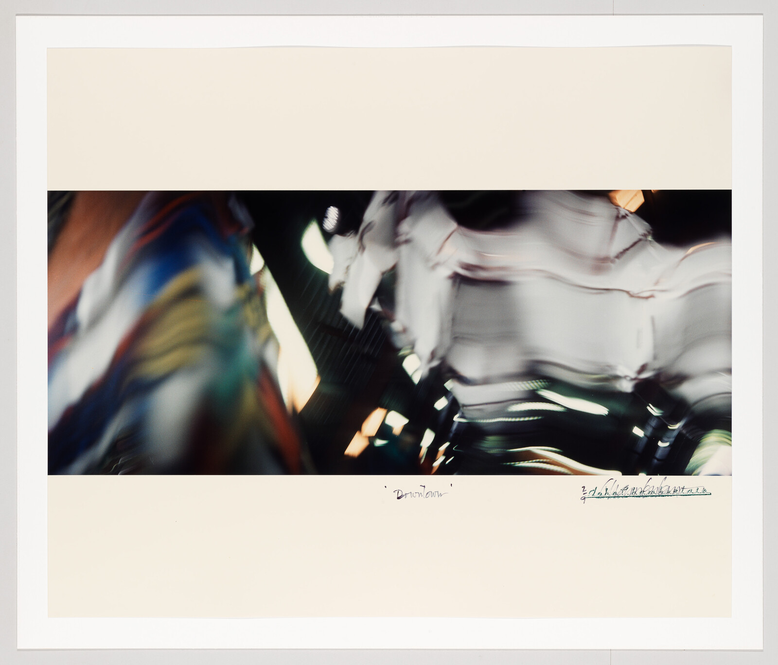 Blurred motion of colorful lights and fabric creating abstract streaks across a dark scene.