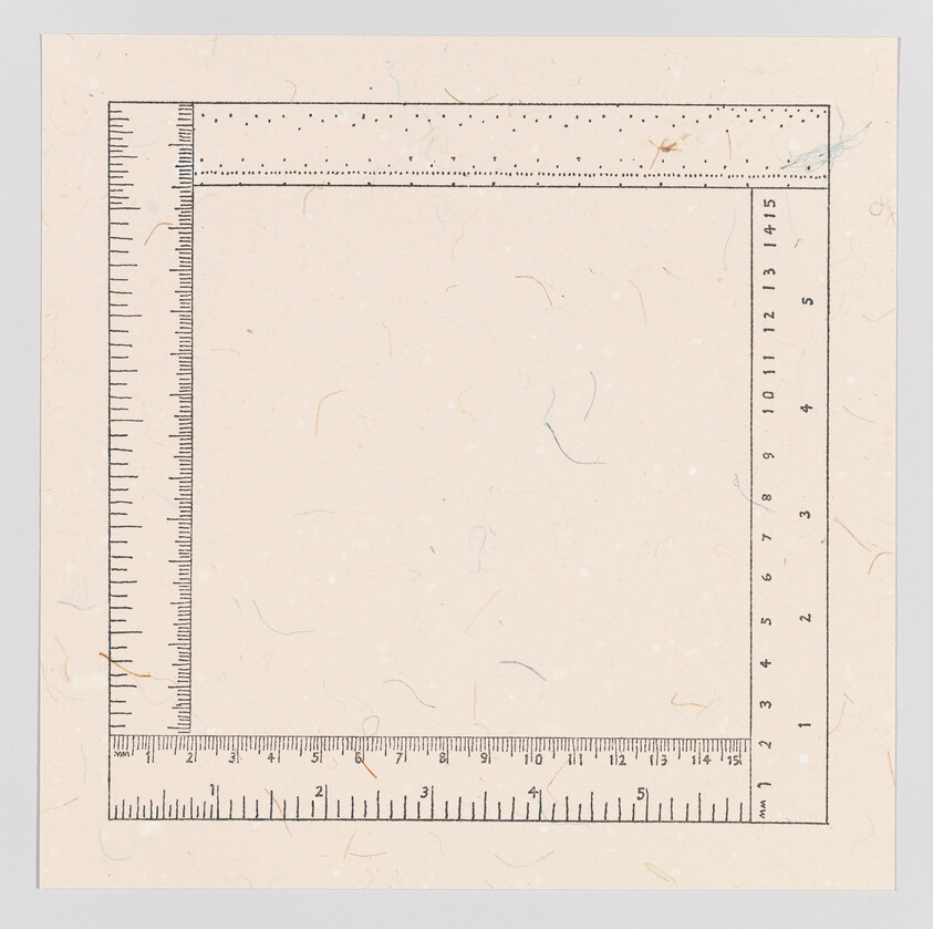 A square piece of paper with a ruler border printed along two adjacent edges, showing measurements in centimeters and millimeters. The paper has a textured appearance with small, colored fibers throughout.