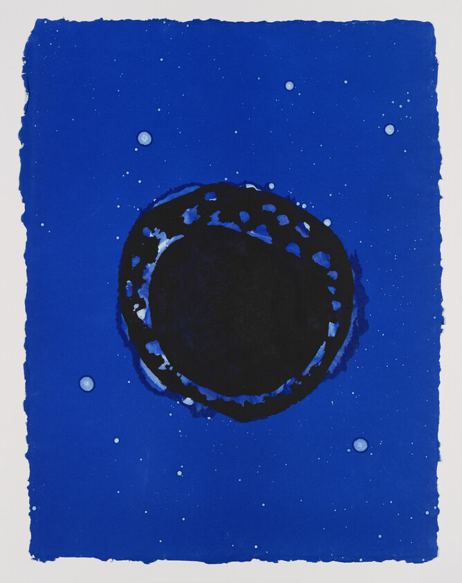 A deep blue background with a large black circular void surrounded by lighter blue speckles.