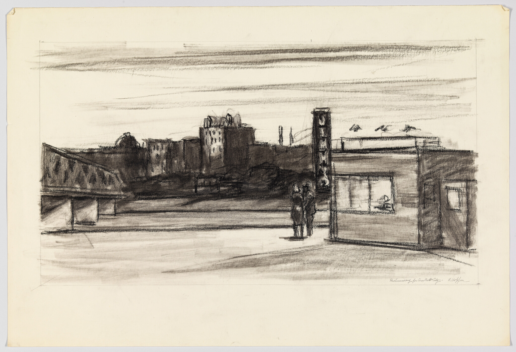 Two people stand by a small street kiosk near a bridge with distant city buildings.