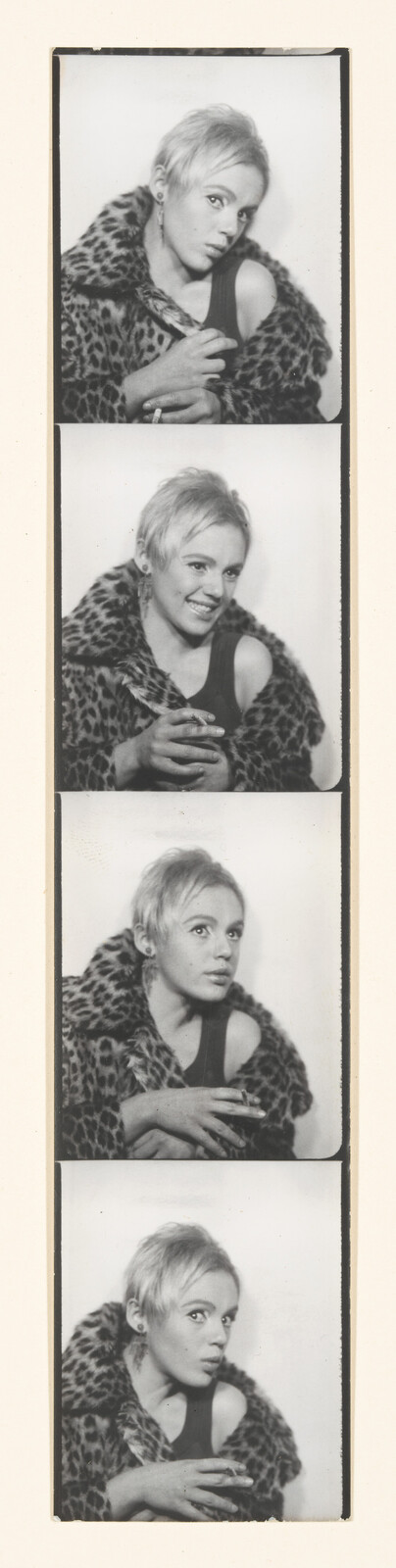 Four black-and-white photo booth strips of a person with short hair wearing a leopard print coat, posing with varying expressions.