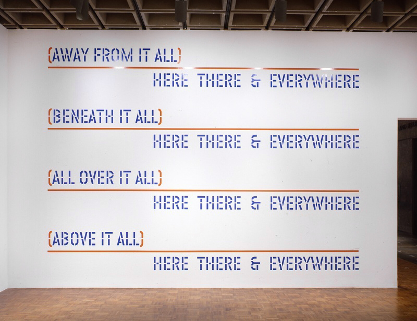 White gallery wall displays four blue stencil phrases like "Away from it all" and "Here there & everywhere."