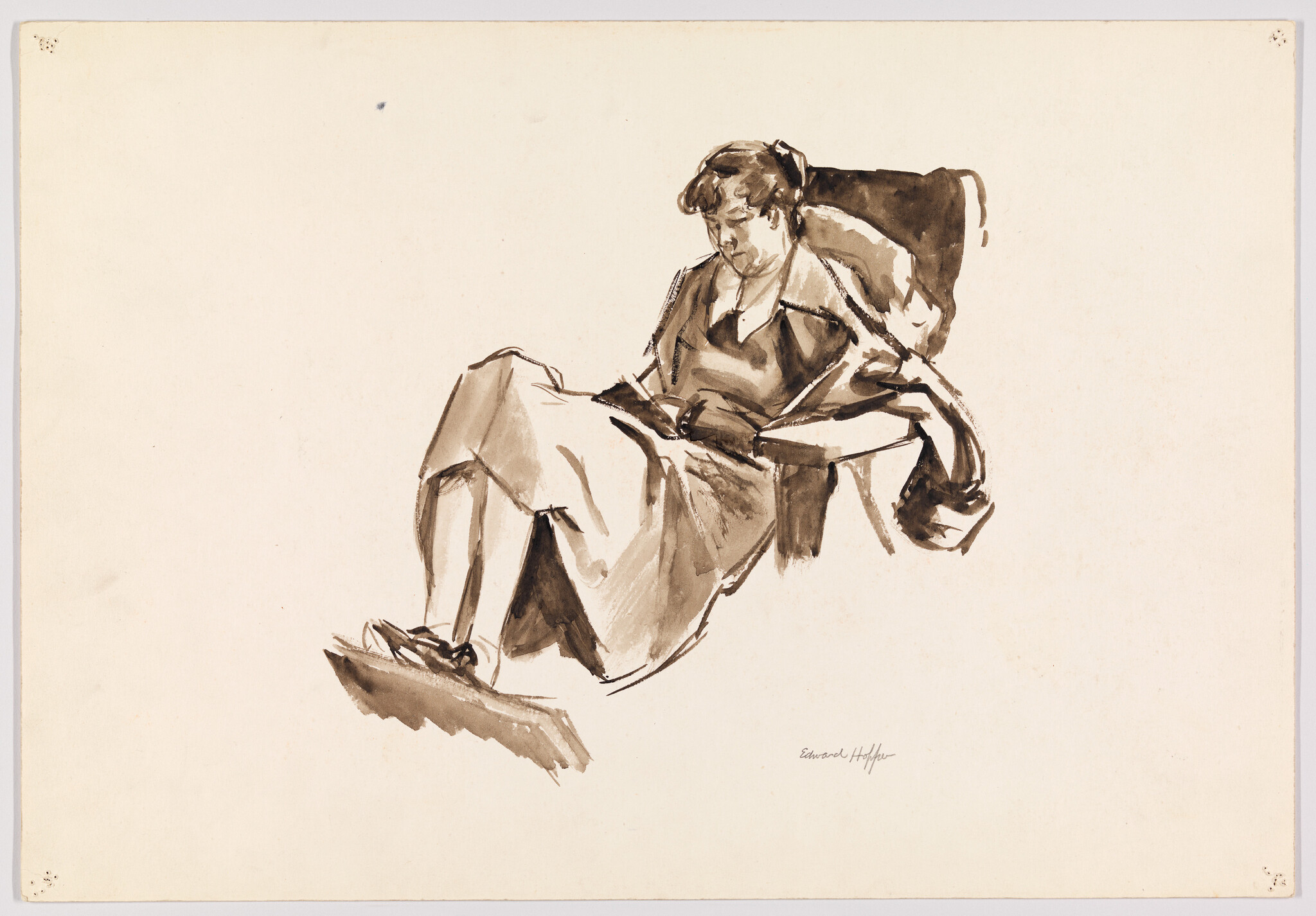 A woman reclining in an armchair with legs outstretched while reading a book.