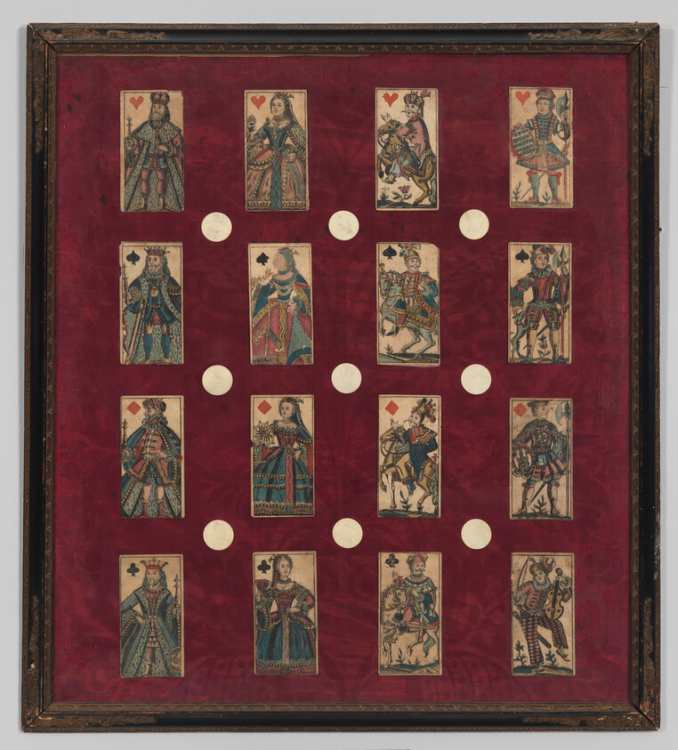 Framed display of fourteen vintage court playing cards arranged on red velvet backing.