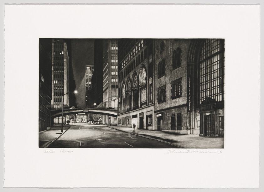 Empty city street at night lined with tall buildings and a pedestrian walking under a skybridge.