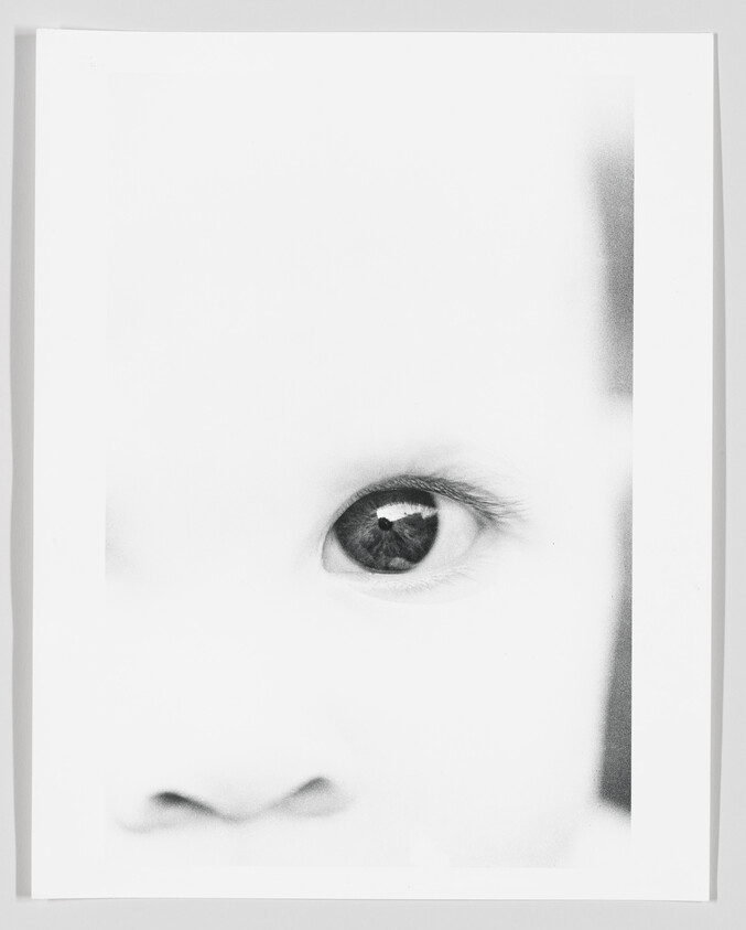 Close-up high-contrast portrait of a baby's eye and nose with a soft, overexposed background.