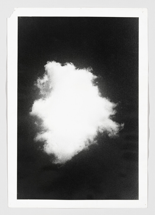 A bright white cloud floats centered against a dark sky in a high-contrast black-and-white print.