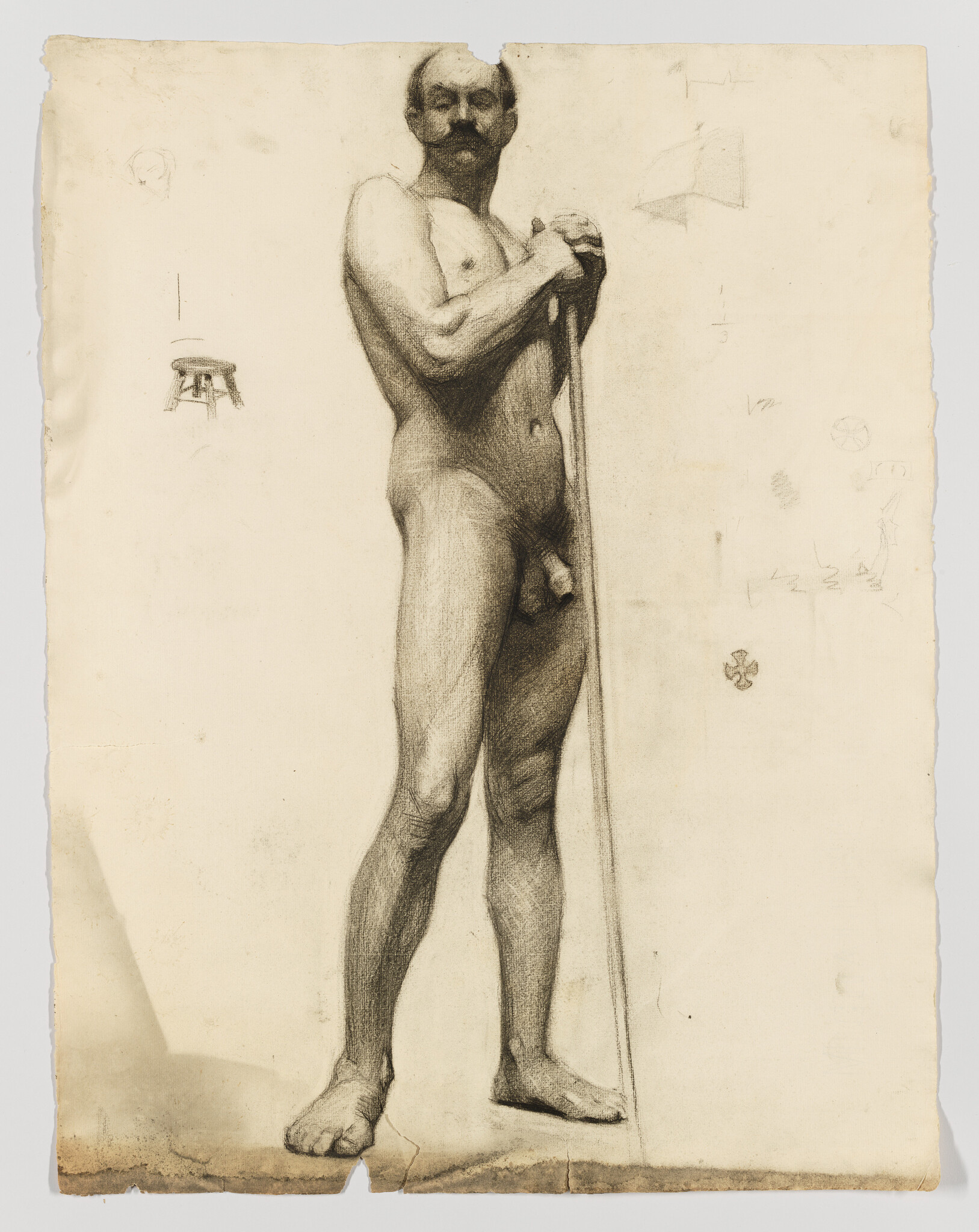 A standing nude man holds a long staff while posing in a classical charcoal study.