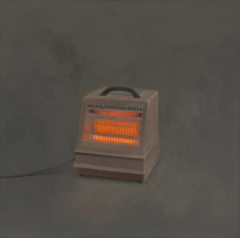 A boxy, hand bag-like heater with a single chord glows orange through its gridded front.