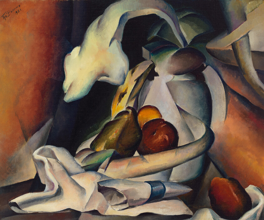 A bowl of fruit and a white pitcher arranged on a table with draped cloth.