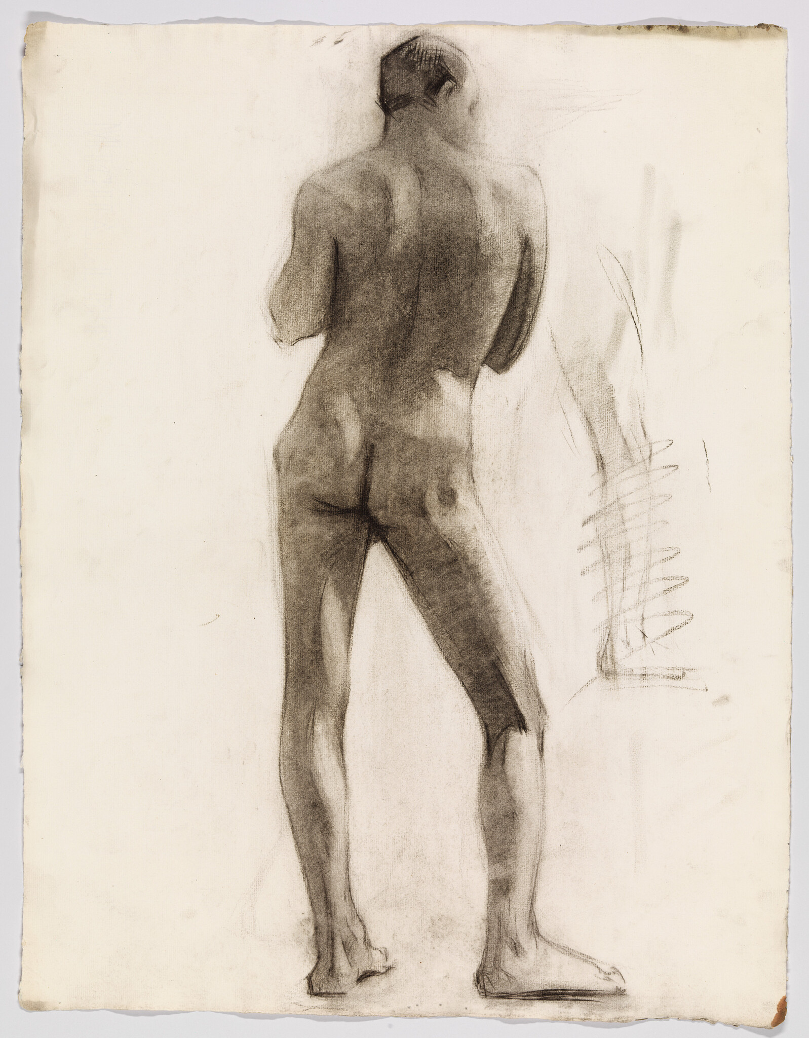A charcoal study of a standing nude man seen from the back, weight on one leg.
