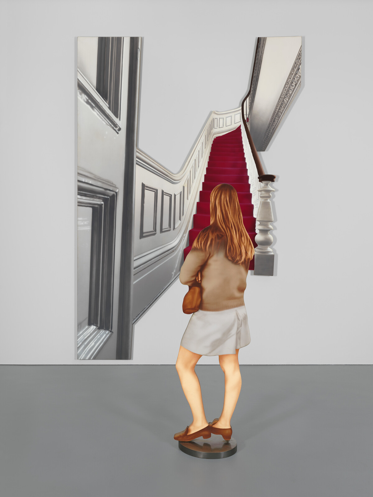 A woman stands in front of an artwork showing a red-carpeted staircase ascending.