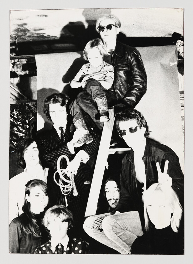 Group of eight people posed around a ladder, one child sitting near the top.