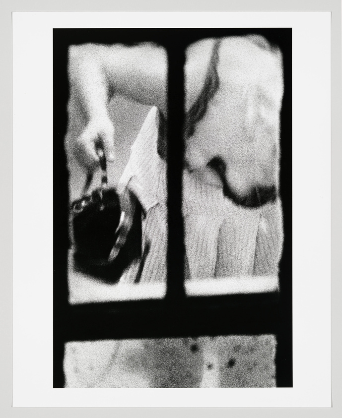 A grainy image seen from a window, shows the arm and chest of a woman as she bends to grad her handbag