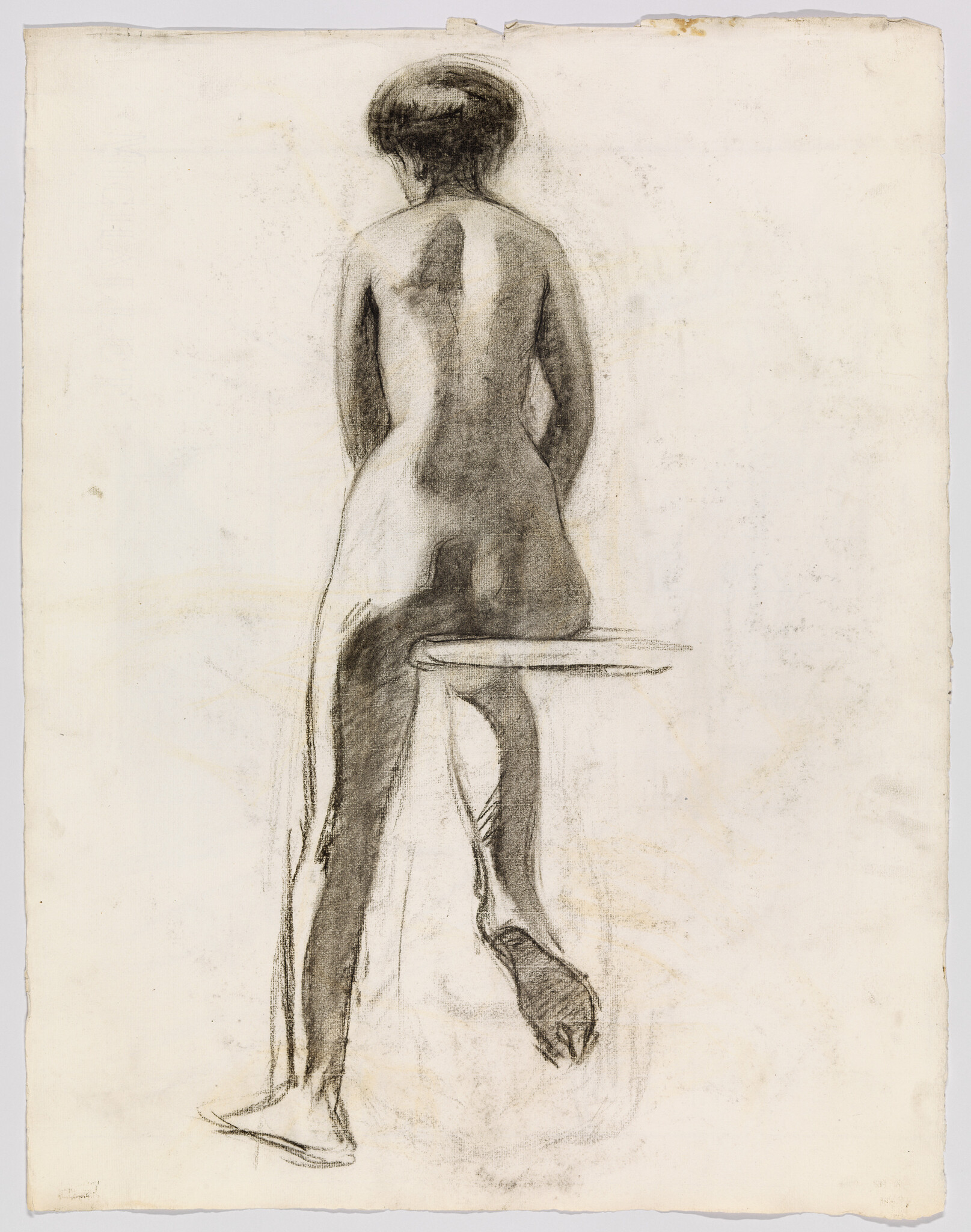 Nude woman seen from behind sitting on a stool with one leg crossed and foot dangling.