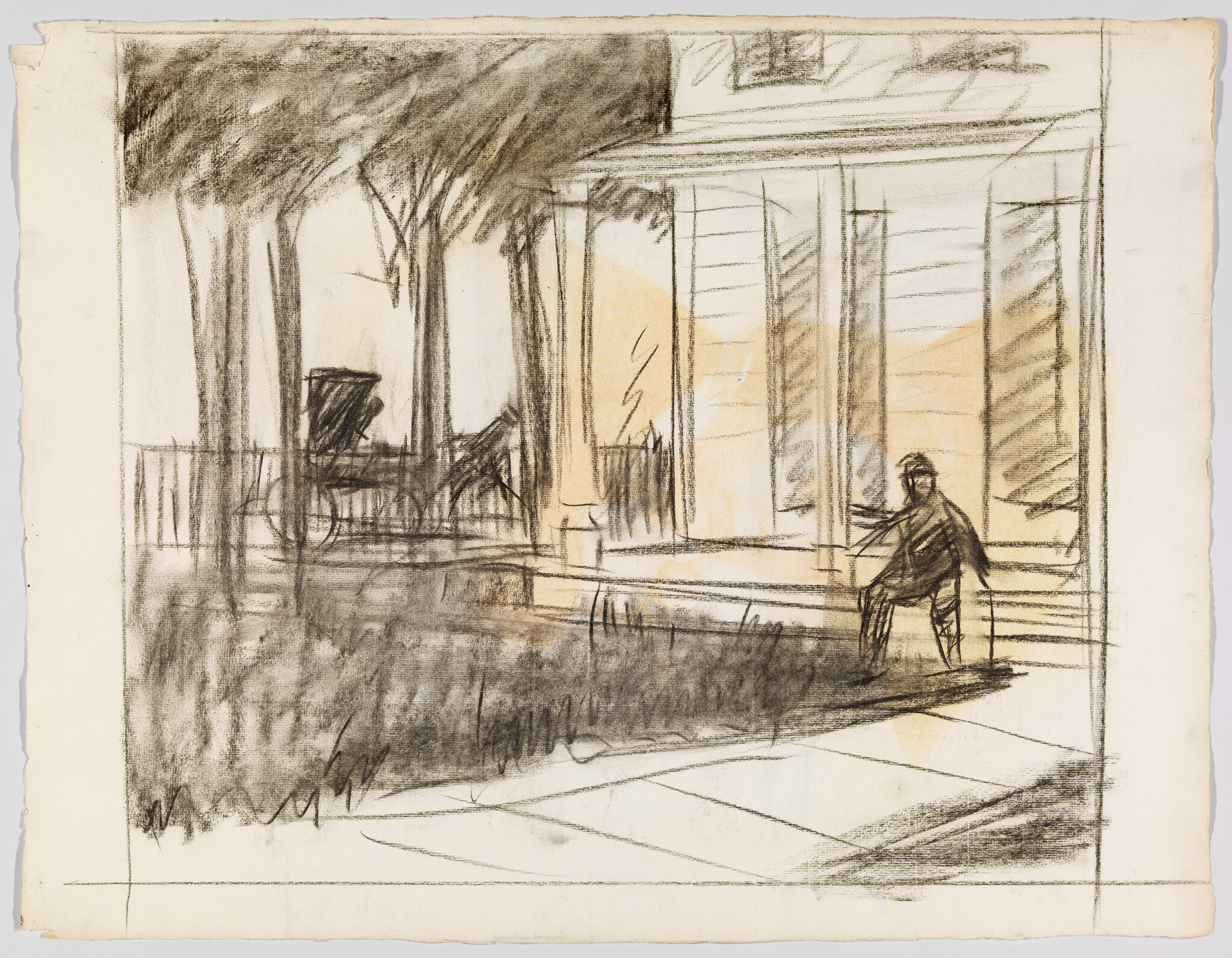 A lone person sits on the front porch steps of a house, shaded by trees.