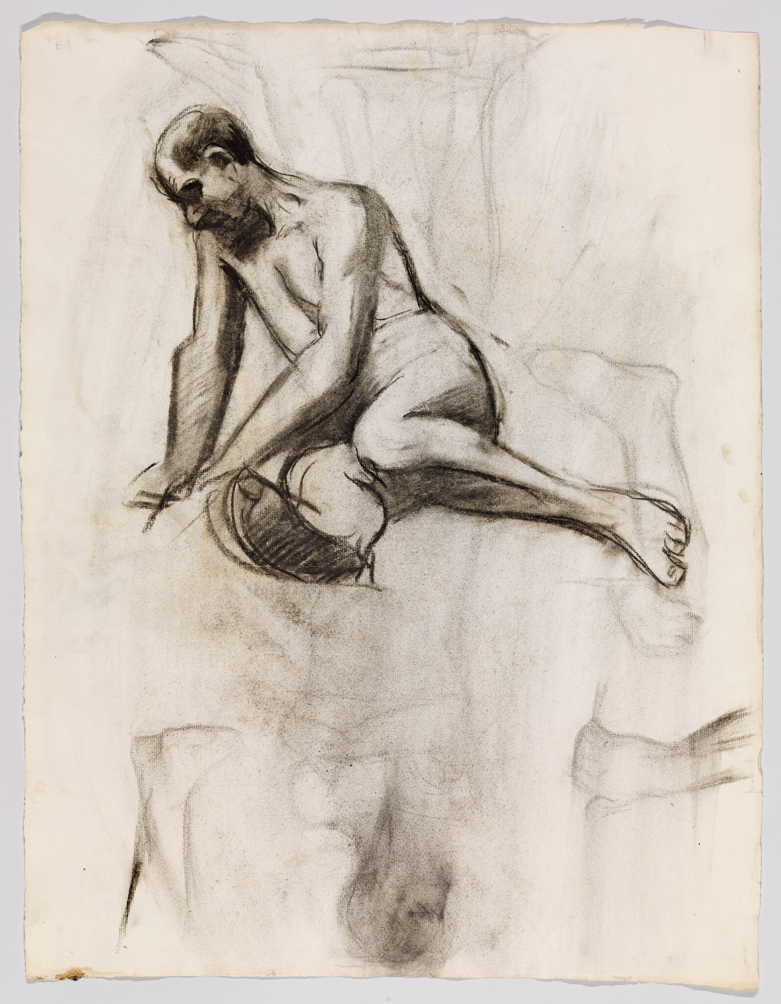 Nude man kneeling on a cushion, leaning forward with head bowed and hand on blanket.