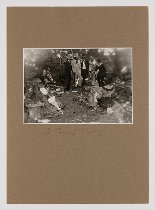 Seven people in period clothing gather outdoors while men examine an object on the ground.
