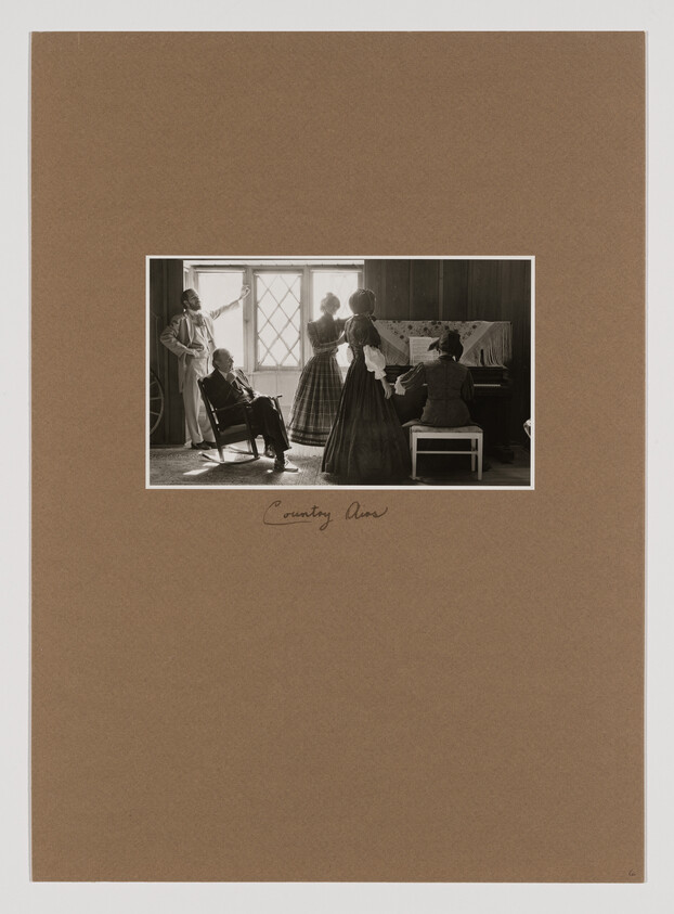 A vintage scene with four people in period clothing; one plays the piano while others stand and sit nearby, framed by a window.