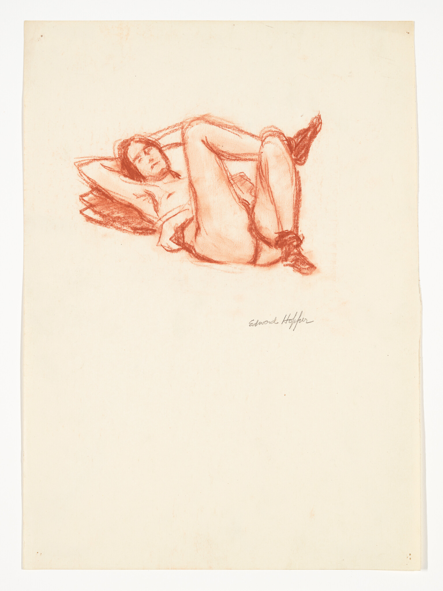 A reclining woman lies on a pillow with bent knees and arms behind her head.