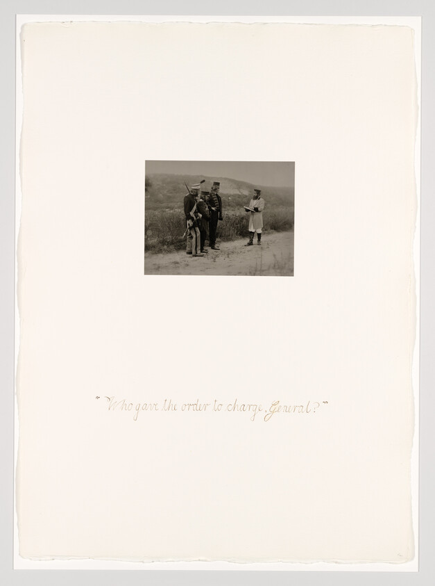 Three soldiers stand in a field while an officer reads orders to them.