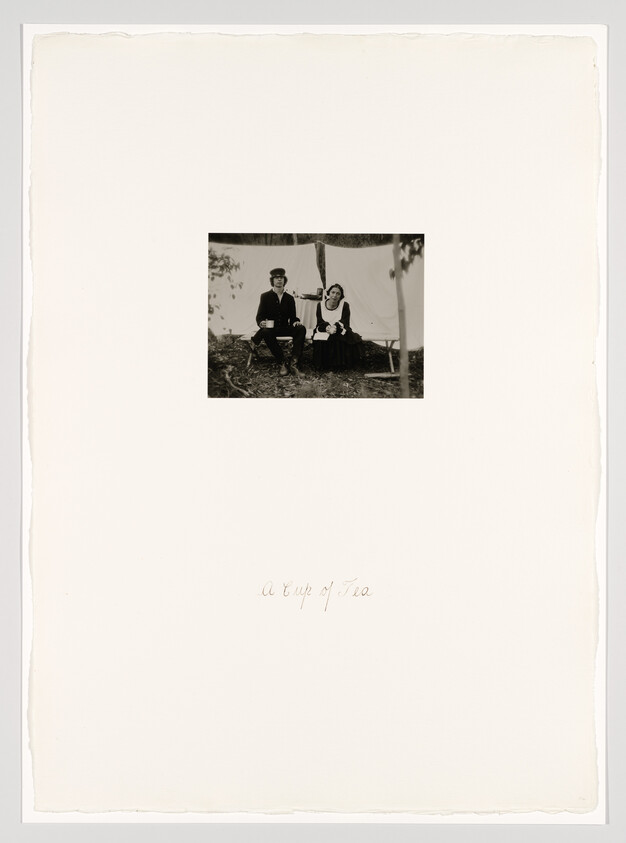 A man and woman sit outdoors at a small table, sharing a cup of tea.