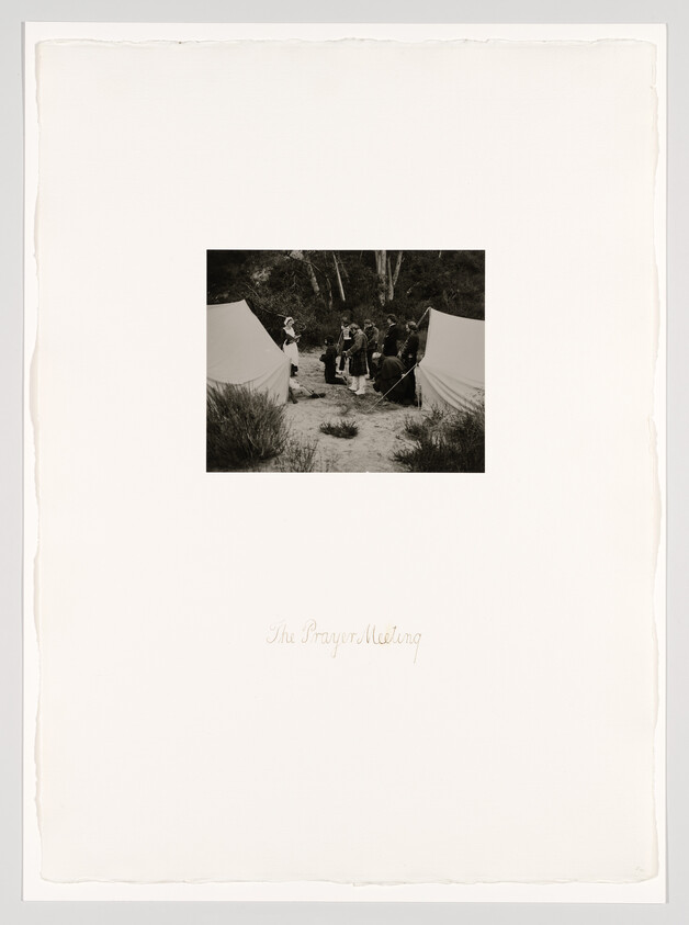 A small group gathers between two tents outdoors for a prayer meeting.