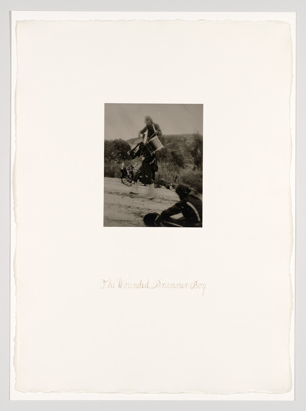 A soldier carries a wounded drummer boy while another sits nearby, captioned the wounded drummer boy.