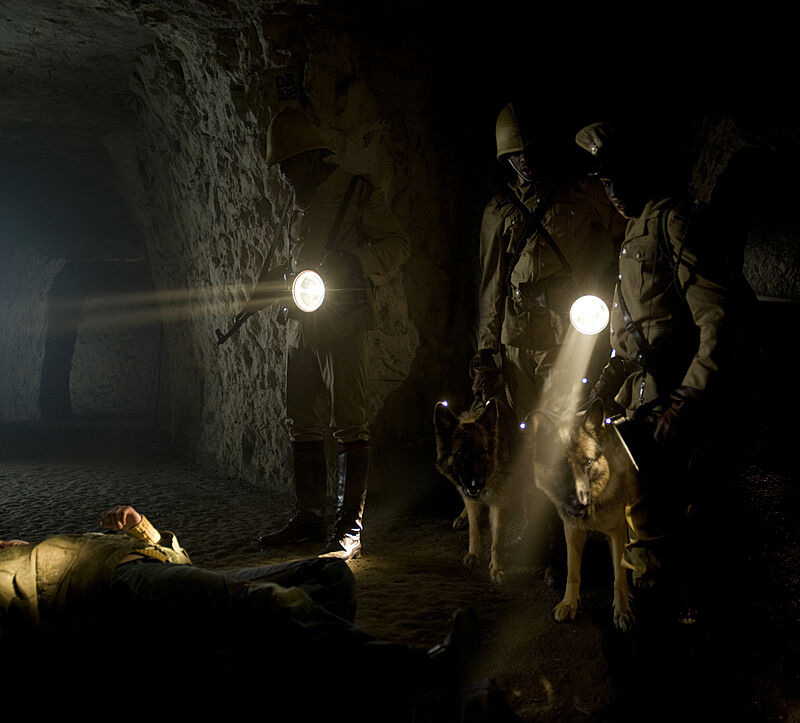 A film still of soldiers holding flashlights in the dark.