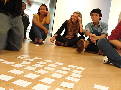 students sitting in front of notecards on floor