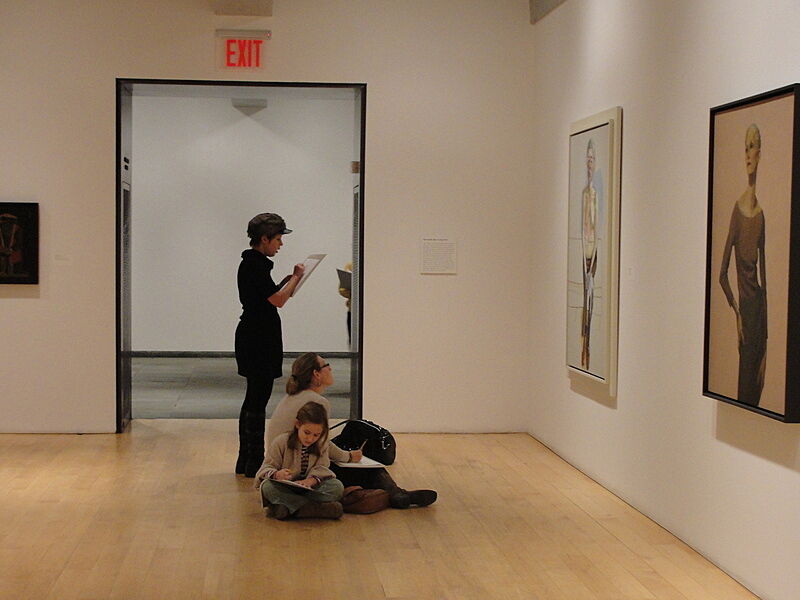 A family sits on the floor of a gallery.