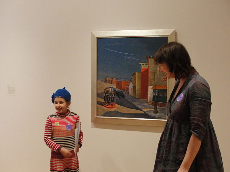 The artist and a child stand in front of a painting.