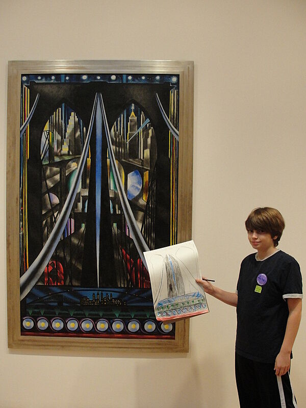 A boy poses with his drawing of a Brooklyn Bridge painting.
