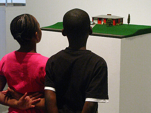two children look at diorama of house