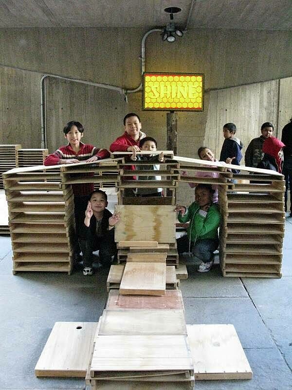 Kids exploring the wood sculpture they built